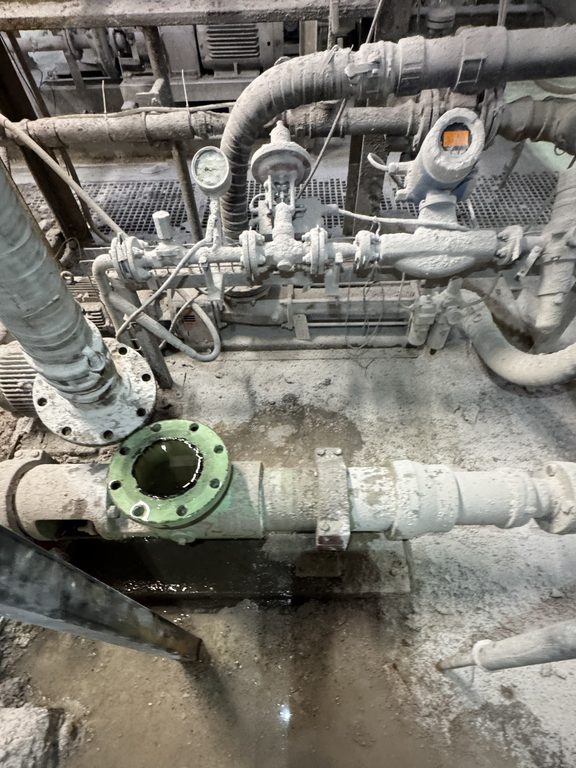The failed pump removed, bare pump base and open flange on the plant floor